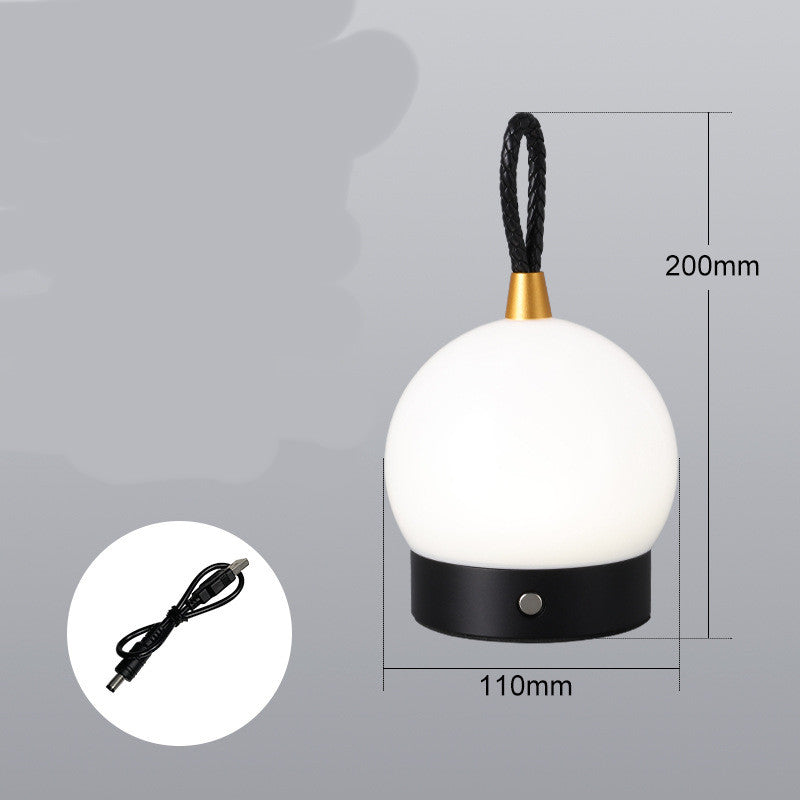 LUMINA™ lampe de table style camping posée sur table extérieure, ambiance soirée