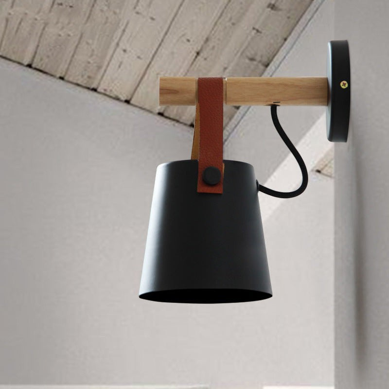 Applique murale Lumeoo STRAP au design scandinave avec support en bois, abat-jour conique noir et sangle en cuir marron.
