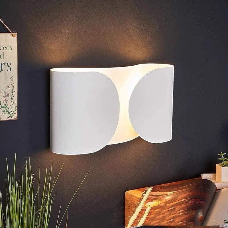Applique murale design moderne Lumeoo blanche aux formes ondulées diffusant une lumière douce sur un mur sombre Image