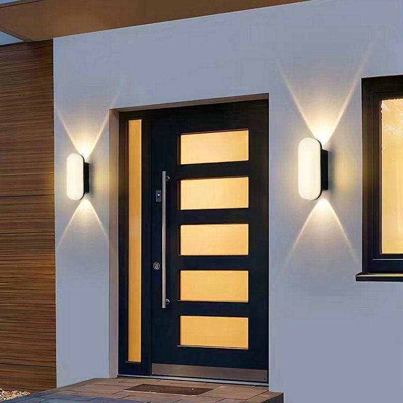 Applique murale extérieure Lumeoo COURYA LED étanche, design ovale moderne diffusant une lumière chaude sur une façade