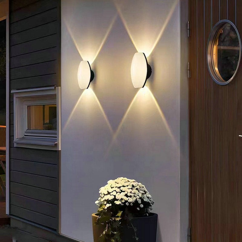 Applique murale extérieure Lumeoo COURYA LED étanche diffusant une lumière chaleureuse en forme de croix sur un mur