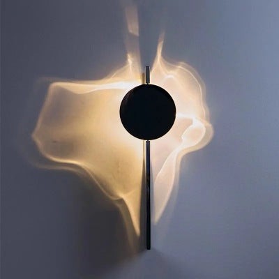 Applique murale Lumeoo STEELIX en inox avec design minimaliste créant un halo lumineux ondulé sur le mur