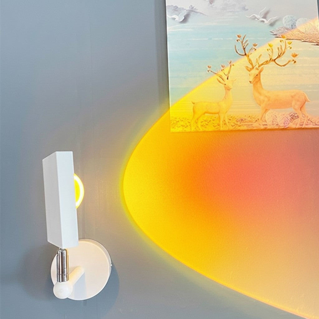 Applique murale LED Lumeoo SUNWALL blanche projetant une lumière chaude de coucher de soleil sur un mur gris.