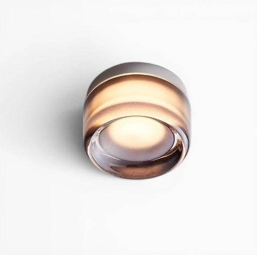 Applique murale LED ronde Lumeoo au design minimaliste diffusant une lumière chaude et enveloppante sur un mur blanc