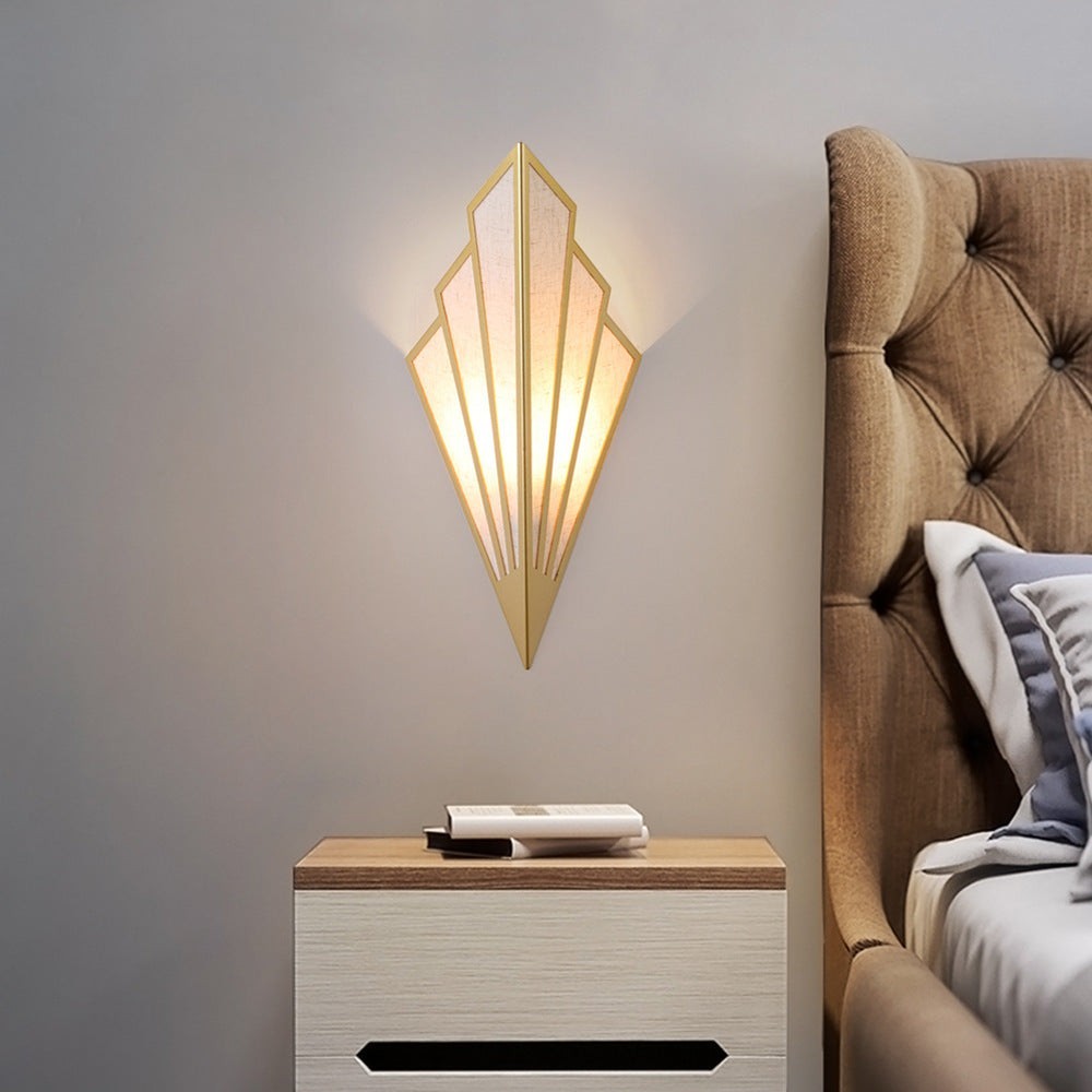 Applique murale LED triangulaire Lumeoo dorée au design géométrique art déco diffusant une lumière douce dans une chambre