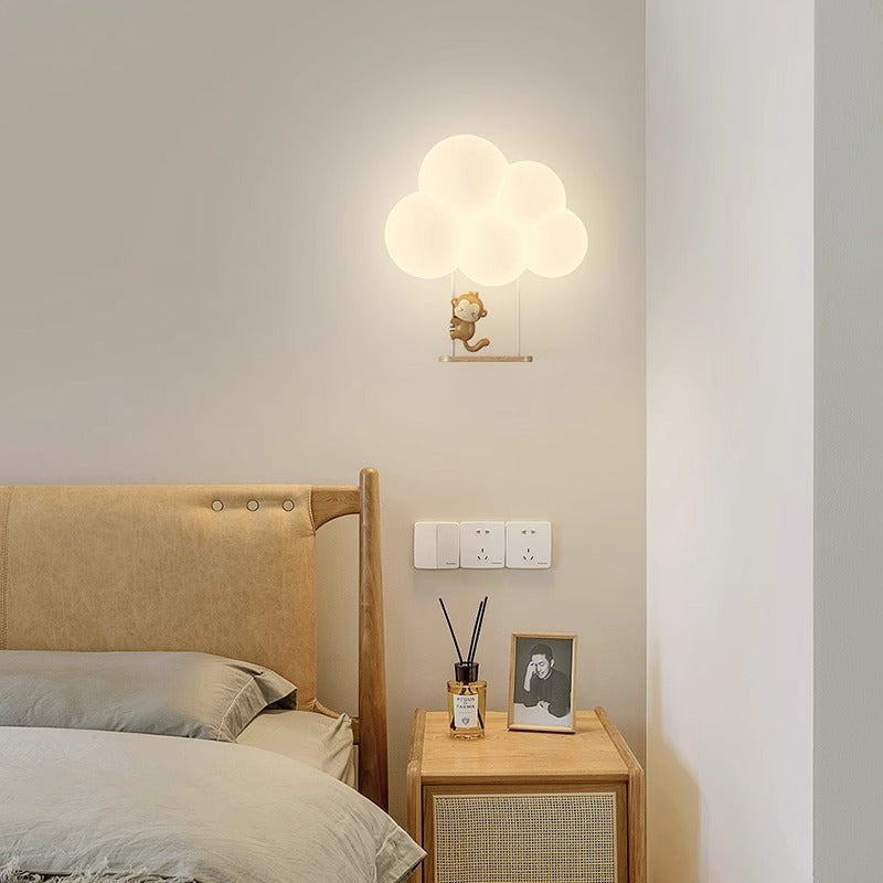 Applique murale Lumeoo KIDIWALL en forme de nuage lumineux avec un petit singe suspendu pour chambre d'enfant