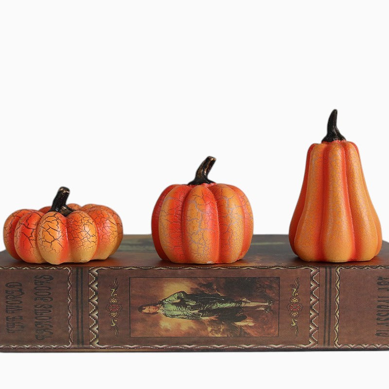 Lumeoo lot de trois citrouilles décoratives en résine orange pour Halloween posées sur un livre ancien