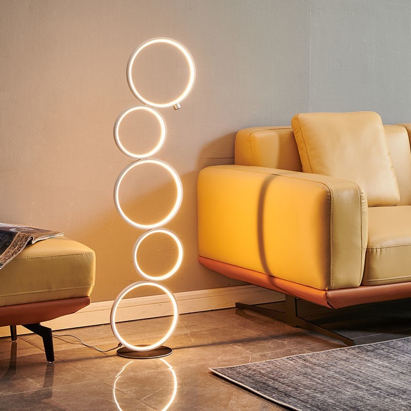 Lampadaire Lumeoo design moderne composé de cinq anneaux lumineux LED empilés dans un salon contemporain