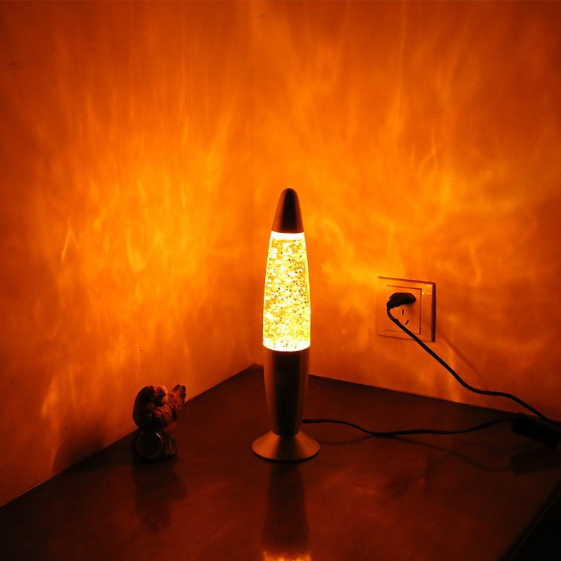 Lampe à lave Lumeoo en aluminium avec paillettes dorées diffusant une lumière orange relaxante sur un mur.