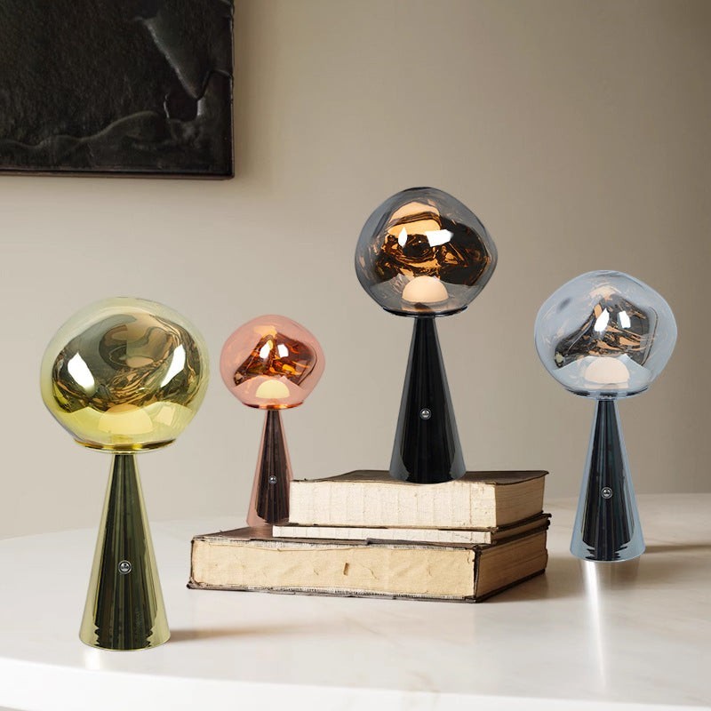Quatre lampes à lave Lumeoo rechargeables au design minimaliste, aux globes en verre coloré et pieds coniques élégants.