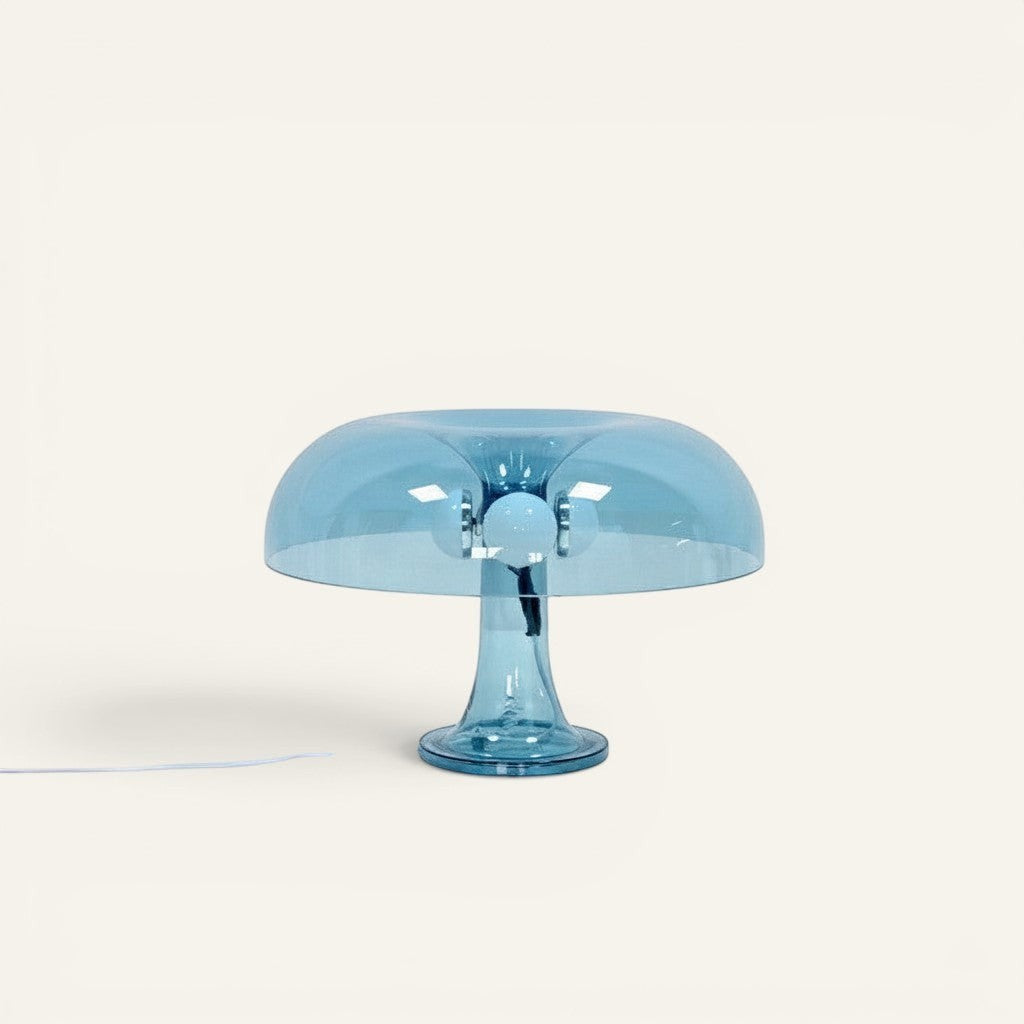 Lampe champignon Lumeoo transparente bleue au design moderne et épuré posée sur une surface blanche