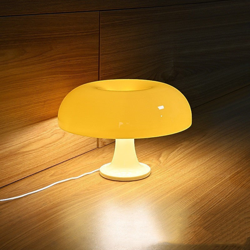 Lampe champignon Lumeoo jaune translucide au design moderne diffusant une lumière douce sur une surface en bois