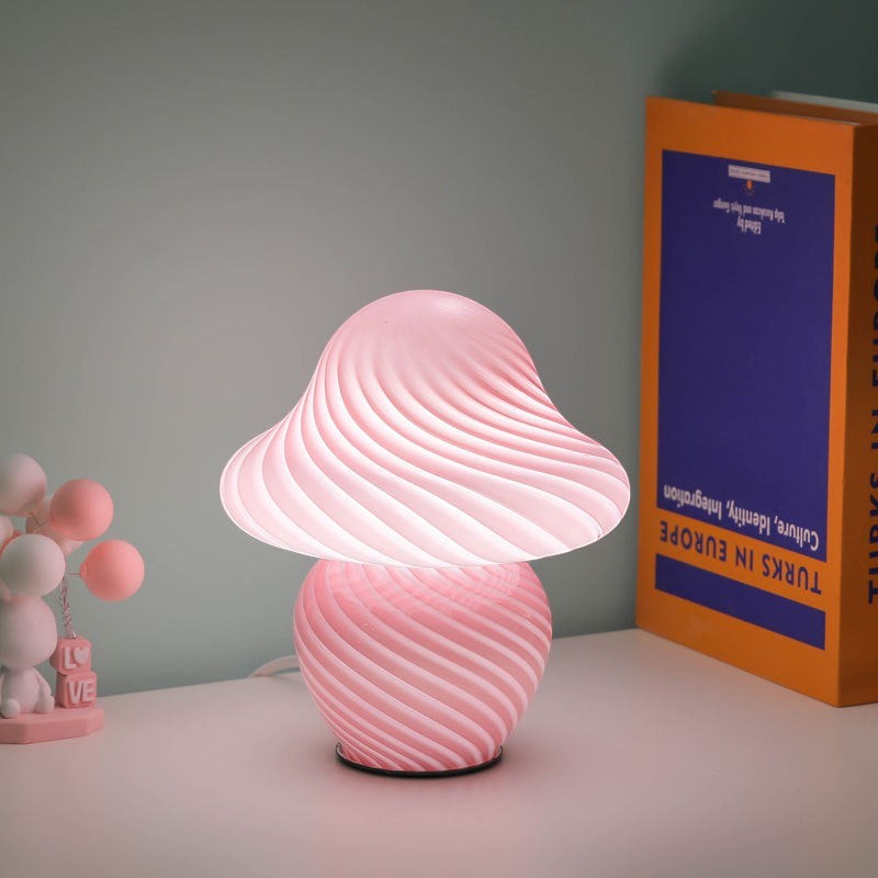 Lampe champignon Lumeoo en pâte de verre rose avec motif torsadé diffusant une lumière douce et chaleureuse