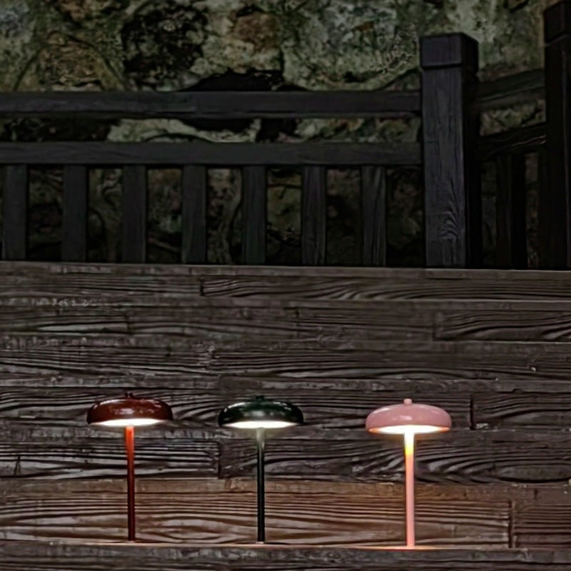 Trois lampes champignon rechargeables Lumeoo en rouge, vert et rose sur un escalier en bois pour une ambiance cosy