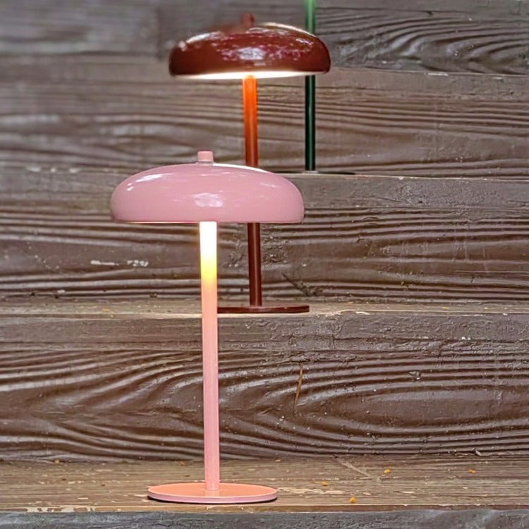 Lampes champignon rechargeables Lumeoo rose et bordeaux au design minimaliste posées sur un escalier en bois