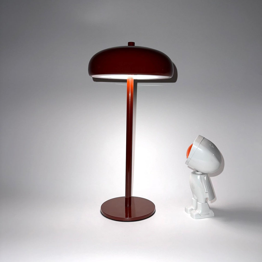 Lampe champignon Lumeoo rouge minimaliste rechargeable posée sur une table avec une figurine décorative blanche
