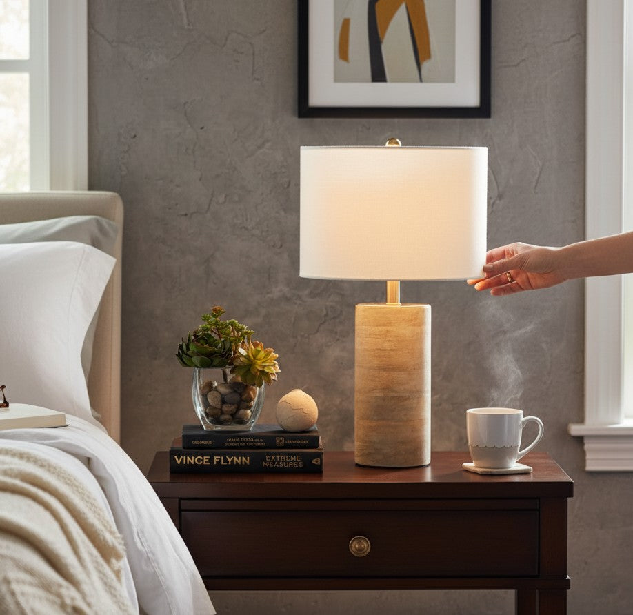 Lampe de chevet Lumeoo avec pied cylindrique en bois naturel et abat-jour blanc sur une table de nuit
