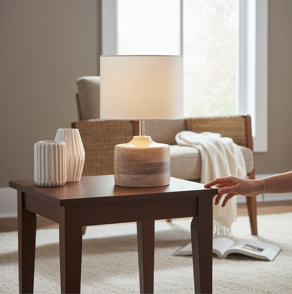 Lampe de chevet Lumeoo en bois naturel et abat-jour blanc posée sur une table en bois dans une chambre cosy Image