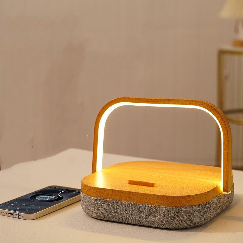 Lampe de chevet Lumeoo 3 en 1 en bois avec enceinte Bluetooth intégrée et chargeur induction pour smartphone.
