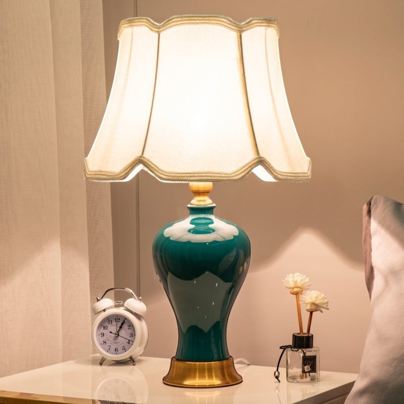 Lampe de chevet Lumeoo style européen avec pied en céramique vert émeraude, base dorée et abat-jour festonné crème