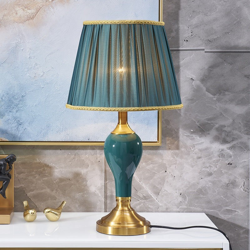 Lampe de chevet Lumeoo en céramique vert émeraude avec abat-jour plissé bleu et base en laiton doré élégante
