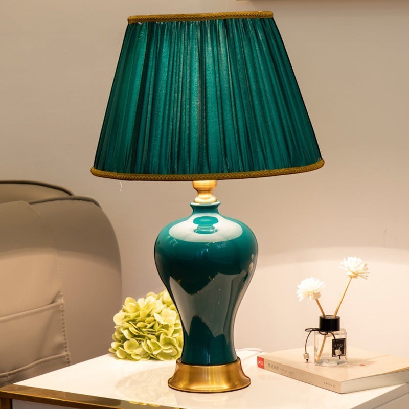 Lampe de chevet Lumeoo style européen avec base en céramique vert émeraude et abat-jour plissé assorti sur table blanche