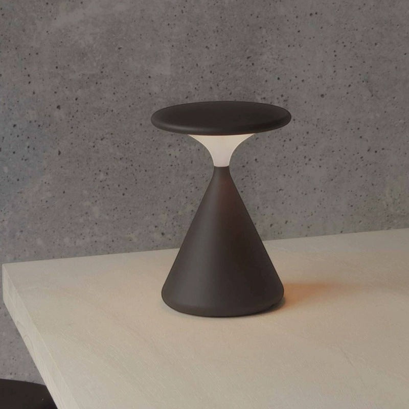 Lampe de chevet minimaliste Lumeoo au design conique gris foncé avec éclairage diffus doux sur une table en bois