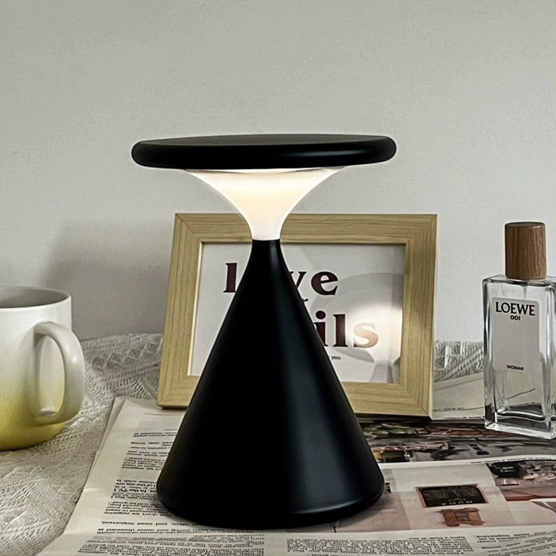 Lampe de chevet minimaliste Lumeoo noire au design conique moderne diffusant une lumière douce sur une table
