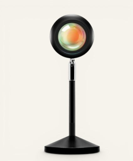 Lampe projecteur Lumeoo Halo diffusant une lumière chaude de coucher de soleil sur pied noir réglable