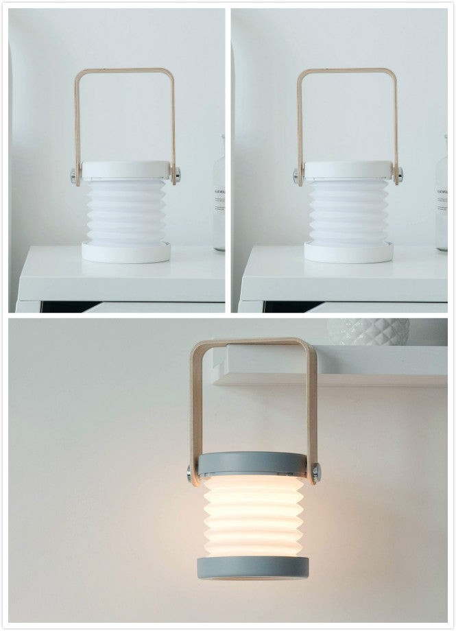 Lanterne LED pliable Lumeoo design scandinave avec anse en bois, tactile et rechargeable, posée ou suspendue.