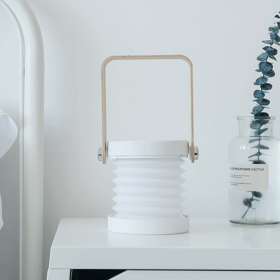 Lanterne LED pliable Lumeoo blanche avec anse en bois, design tactile rechargeable pour une décoration intérieure cosy