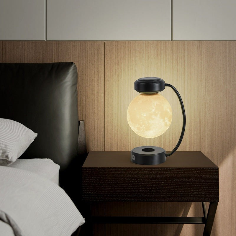 Lampe lune Lumeoo en lévitation magnétique avec éclairage LED chaud sur une table de chevet moderne.