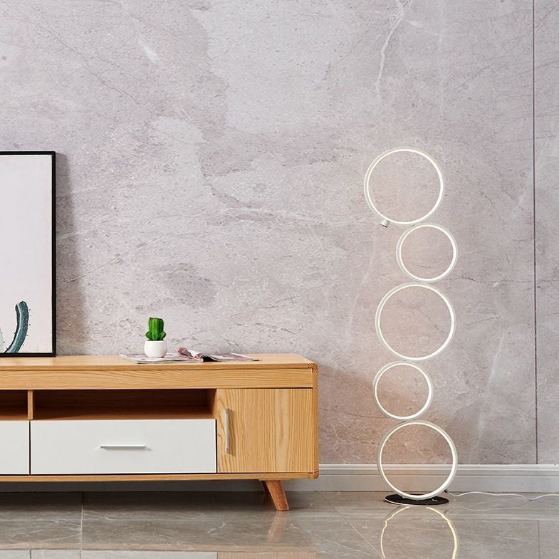 Lampe sur pied Lumeoo au design minimaliste avec cinq anneaux lumineux LED empilés dans un salon moderne
