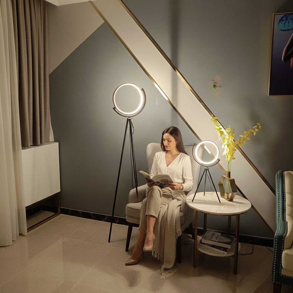 Femme lisant dans un fauteuil avec deux lampes sur pied Lumeoo LED circulaires dimmables en aluminium noir