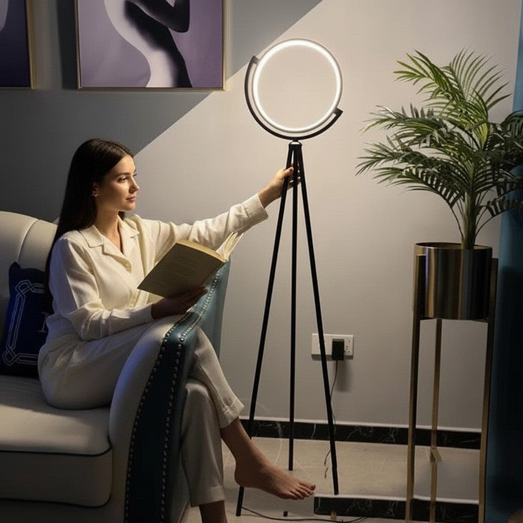Femme lisant près d'un lampadaire sur pied Lumeoo ALULUX LED circulaire noir dimmable dans un salon moderne
