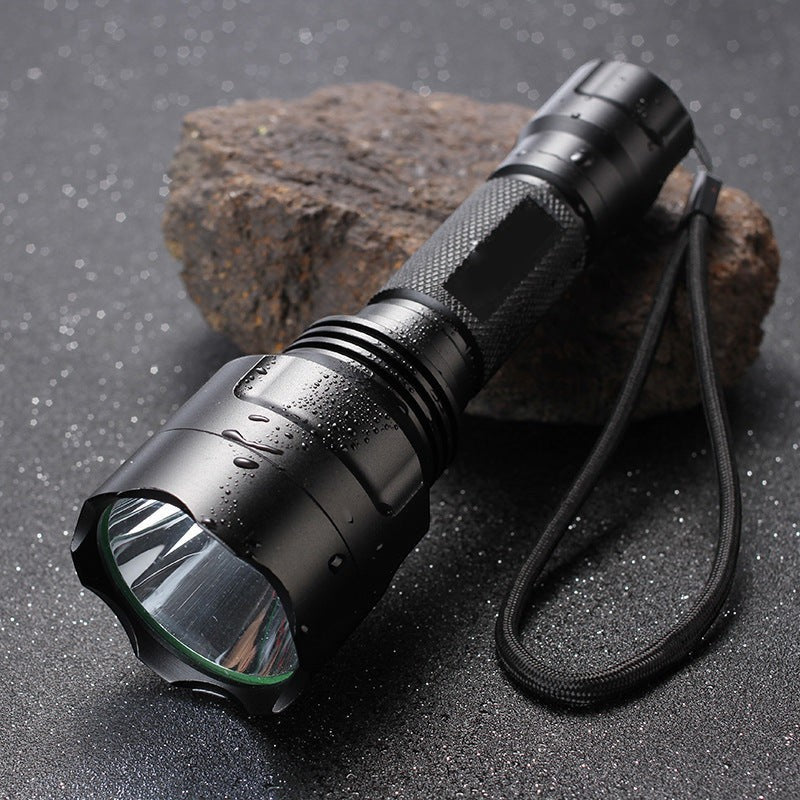 Lampe de poche LED Lumeoo BEAMOX en aluminium noir, rechargeable, robuste et résistante à l'eau sur un rocher.