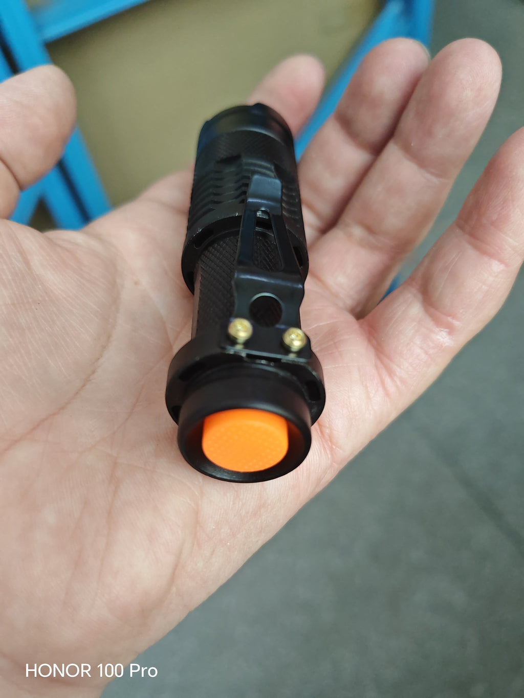 Lampe de poche LED COB Lumeoo rechargeable en aluminium noir avec bouton orange, tenue en main