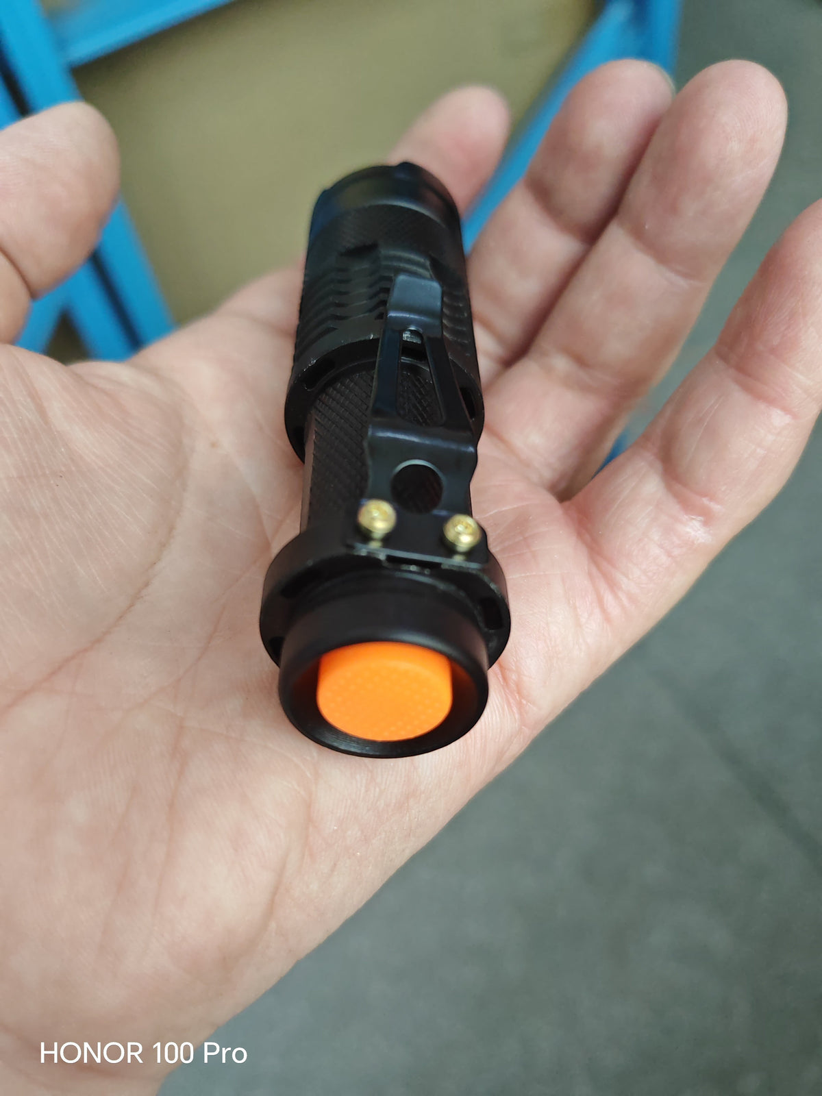 Lampe de poche LED COB Lumeoo rechargeable en aluminium noir avec bouton orange, tenue en main