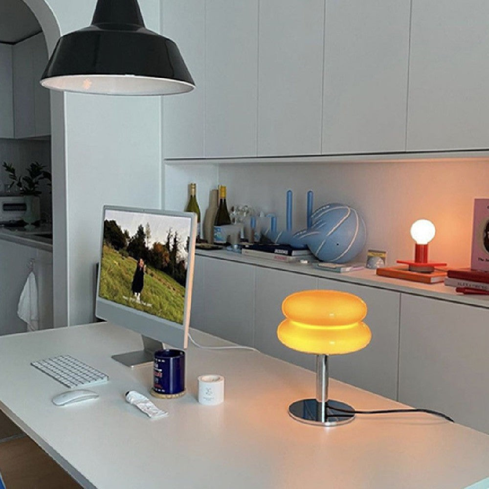 Lampe à poser Lumeoo Verrux en verre jaune et fer, style nordique, dimmable sur un bureau moderne.
