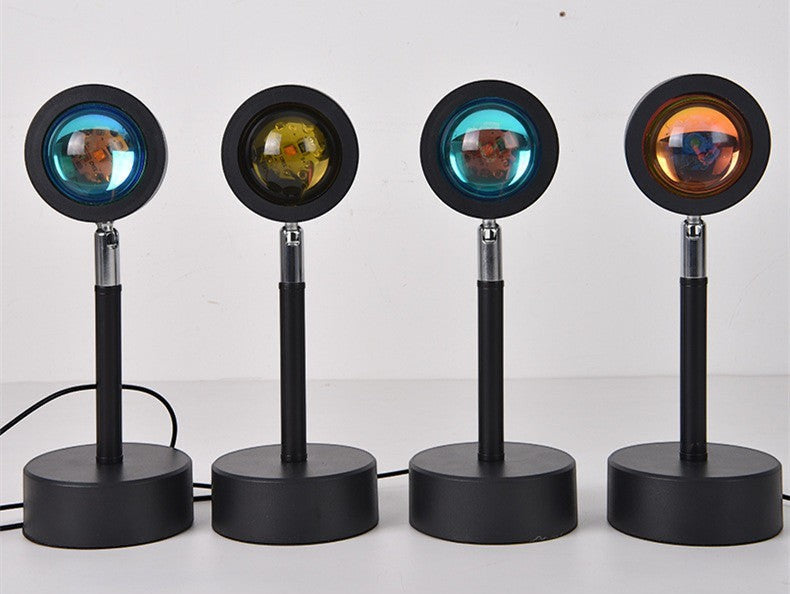 Quatre lampes projecteur coucher de soleil Lumeoo avec socles noirs et têtes orientables pour ambiance lumineuse