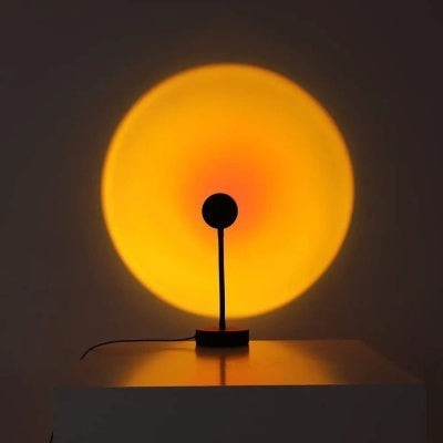Lampe Lumeoo RAINOVA projetant un cercle lumineux aux teintes chaudes de coucher de soleil sur un mur