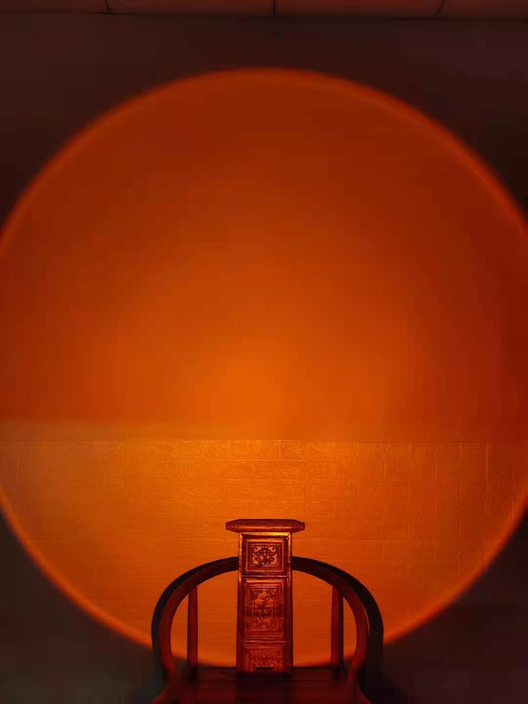 Lampe Lumeoo projetant une lumière chaude et circulaire façon coucher de soleil sur un mur pour une ambiance zen