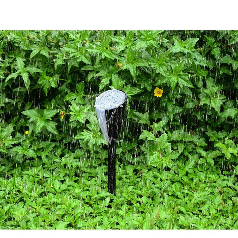 Borne solaire Lumeoo SONOVA bicolore avec haut-parleur LED, installée dans une pelouse sous une pluie fine.