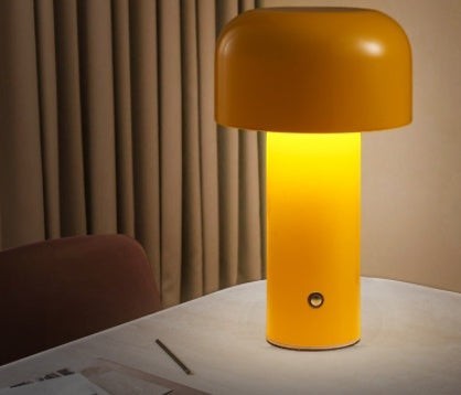 Lampe de table champignon Lumeoo jaune tactile au design moderne et épuré posée sur une table