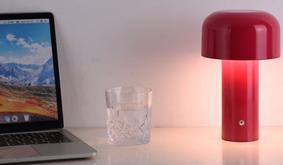 Lampe de table champignon Lumeoo rouge tactile avec lumière douce sur un bureau près d'un ordinateur portable