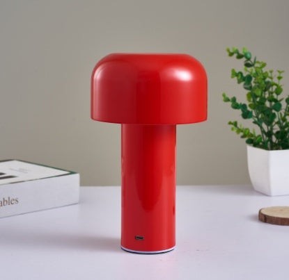 Lampe de table champignon Lumeoo rouge tactile au design moderne et épuré posée sur un bureau