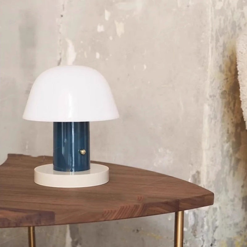 Lampe de table champignon Lumeoo tactile rechargeable avec abat-jour blanc et pied bleu sur une table en bois