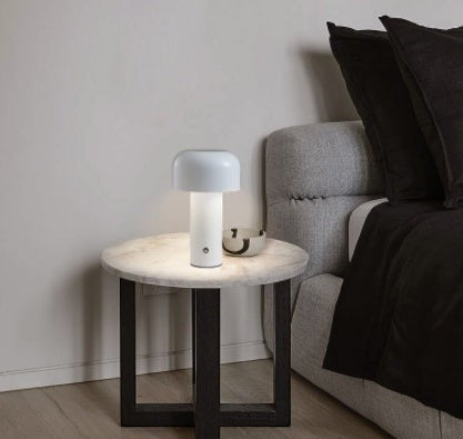 Lampe de table champignon tactile Lumeoo blanche au design moderne posée sur une table de chevet en marbre