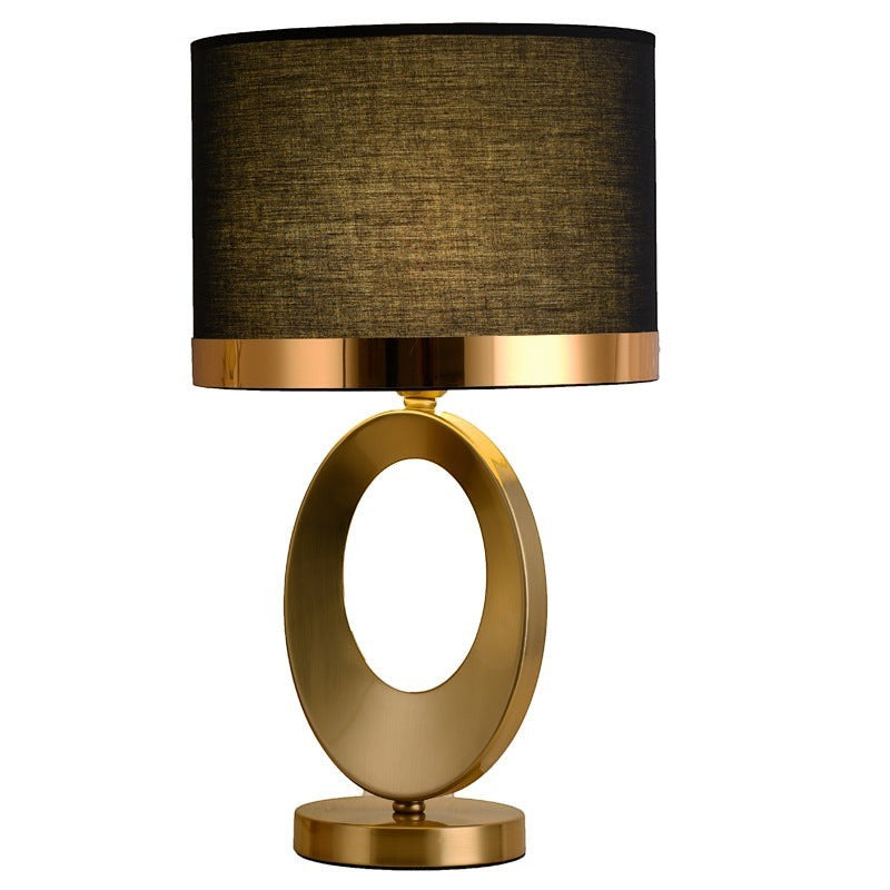 Lampe de table Lumeoo design moderne avec base ovale dorée en métal et abat-jour cylindrique en tissu noir