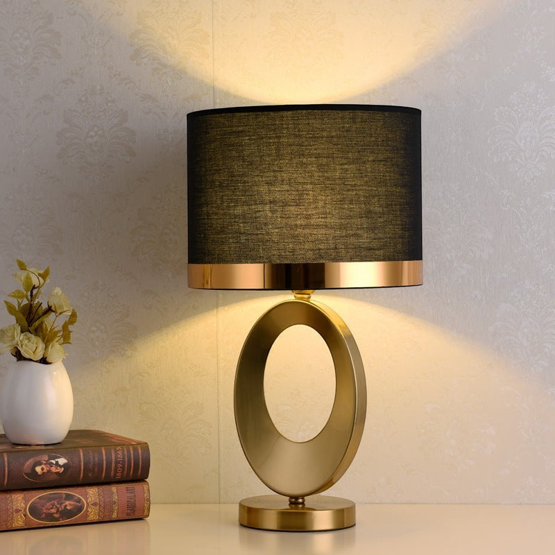 Lampe de table Lumeoo moderne avec pied ovale doré et abat-jour cylindrique noir pour salon ou chevet